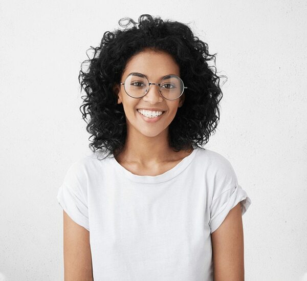 امرأة مبتسمة أمام خلفية بيضاء.